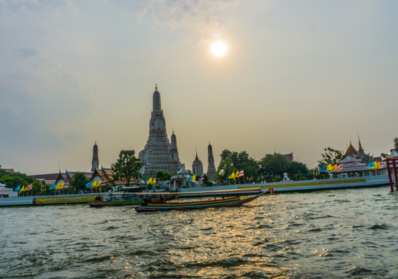 Wat Arun beside the Chao Phraya River at sunset